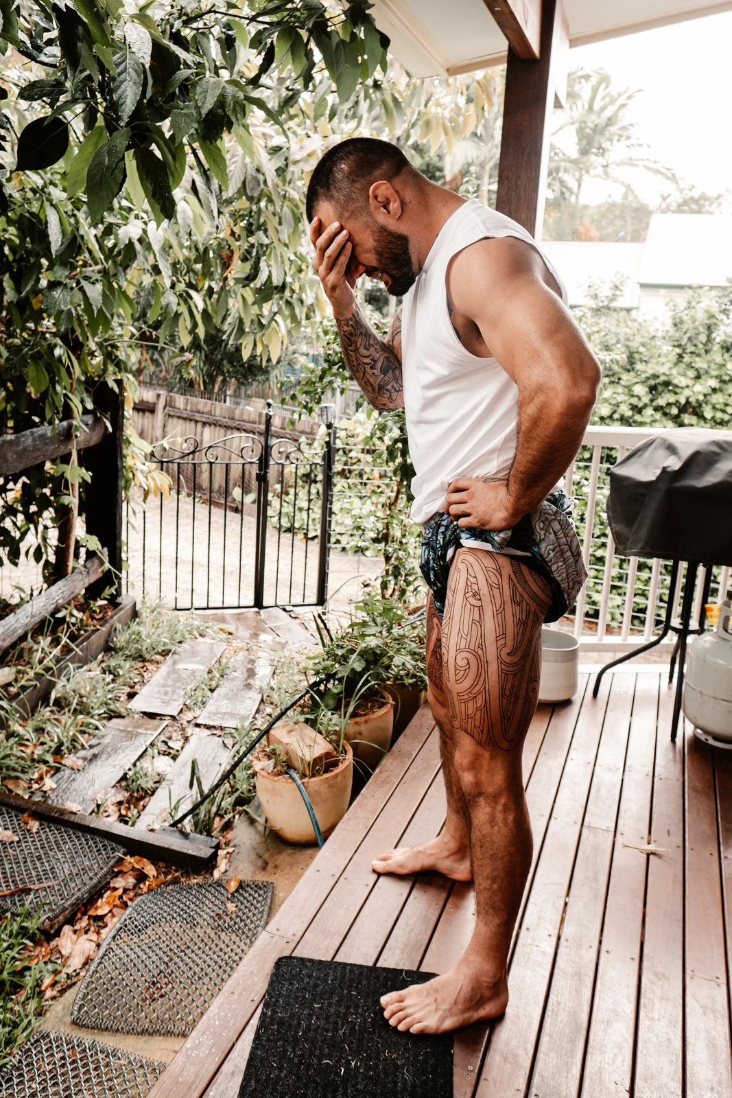 Maori man standing on a veranda showing his pūhoro