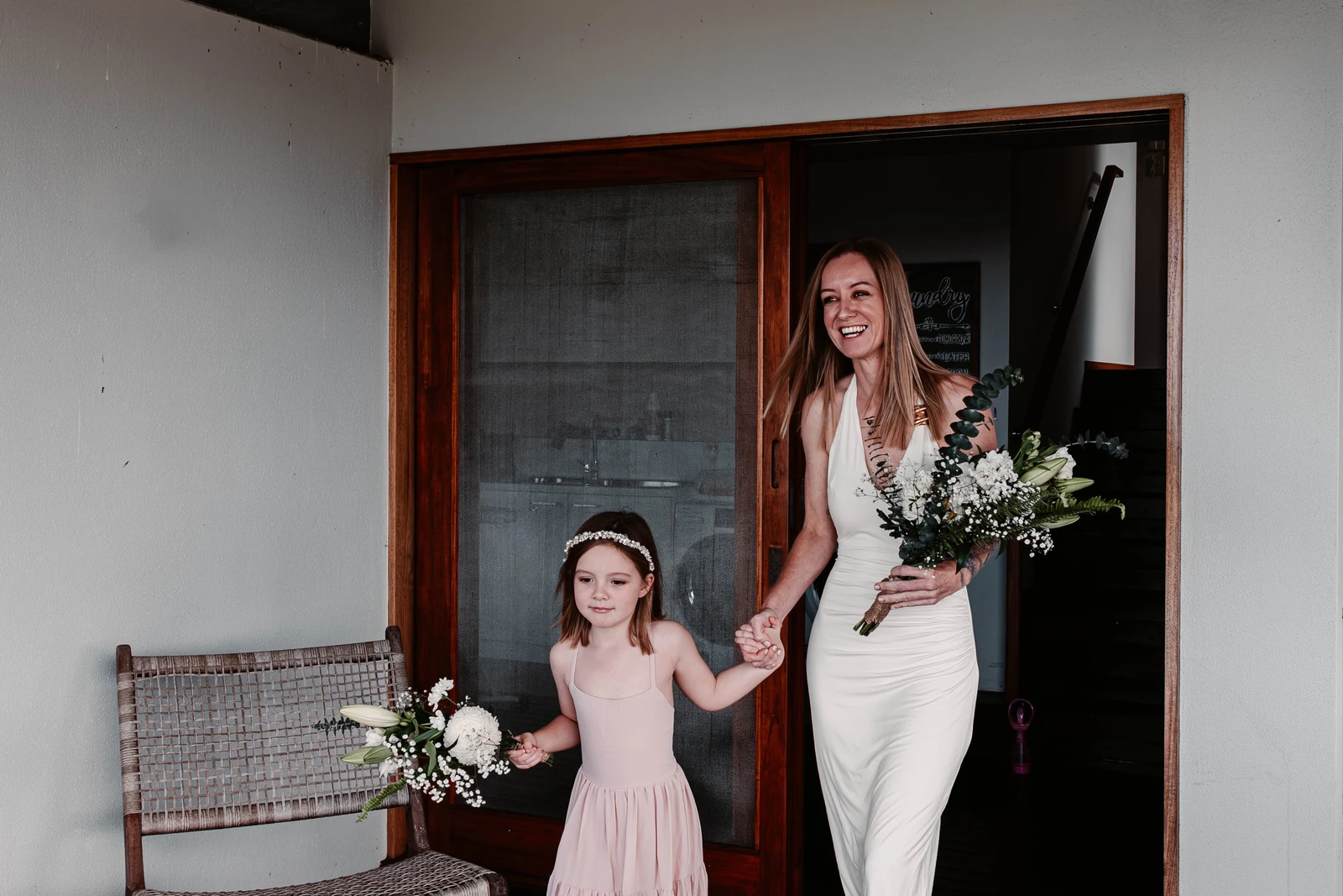 Linzi and Jorja holding hands and bouquets at an elopement