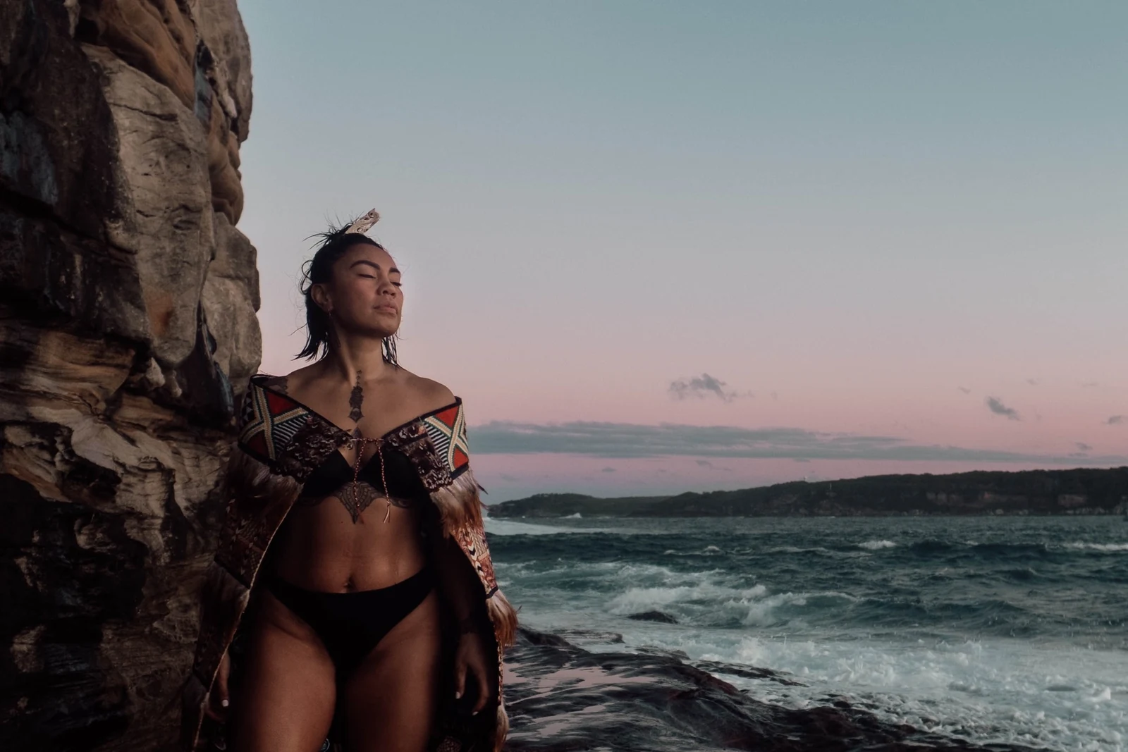 Portrait beside coastal cliffs at dusk